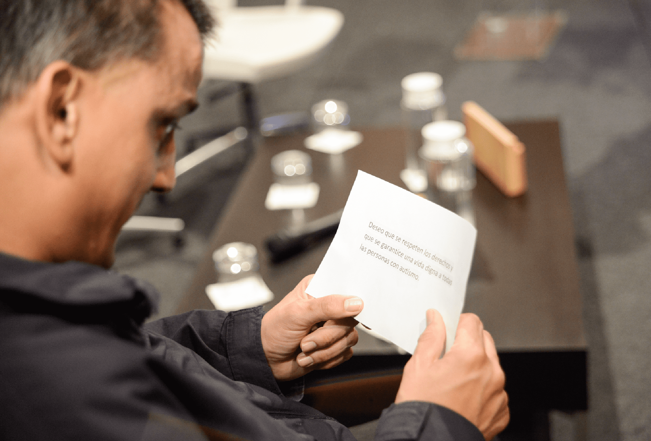 Persona con autismo leyendo una frase escrita en una tarjeta