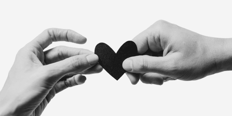 Miniatura de dos manos sujetando un corazón de papel