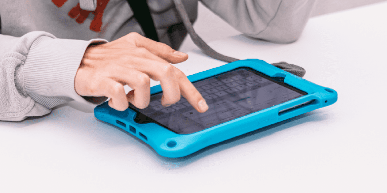 Mano de un niño tocando la pantalla táctil de una tablet