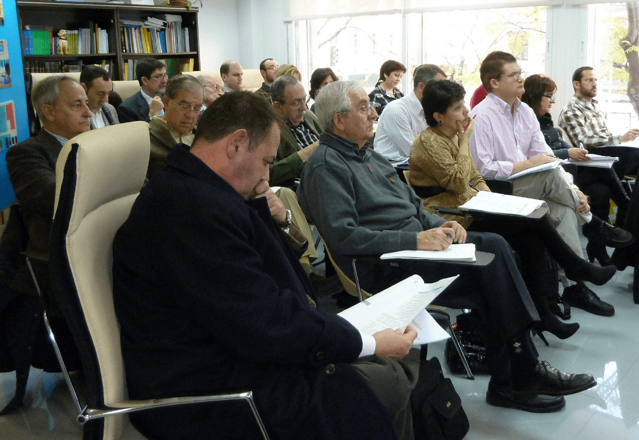 Un grupo de personas sentadas asistiendo a una conferencia