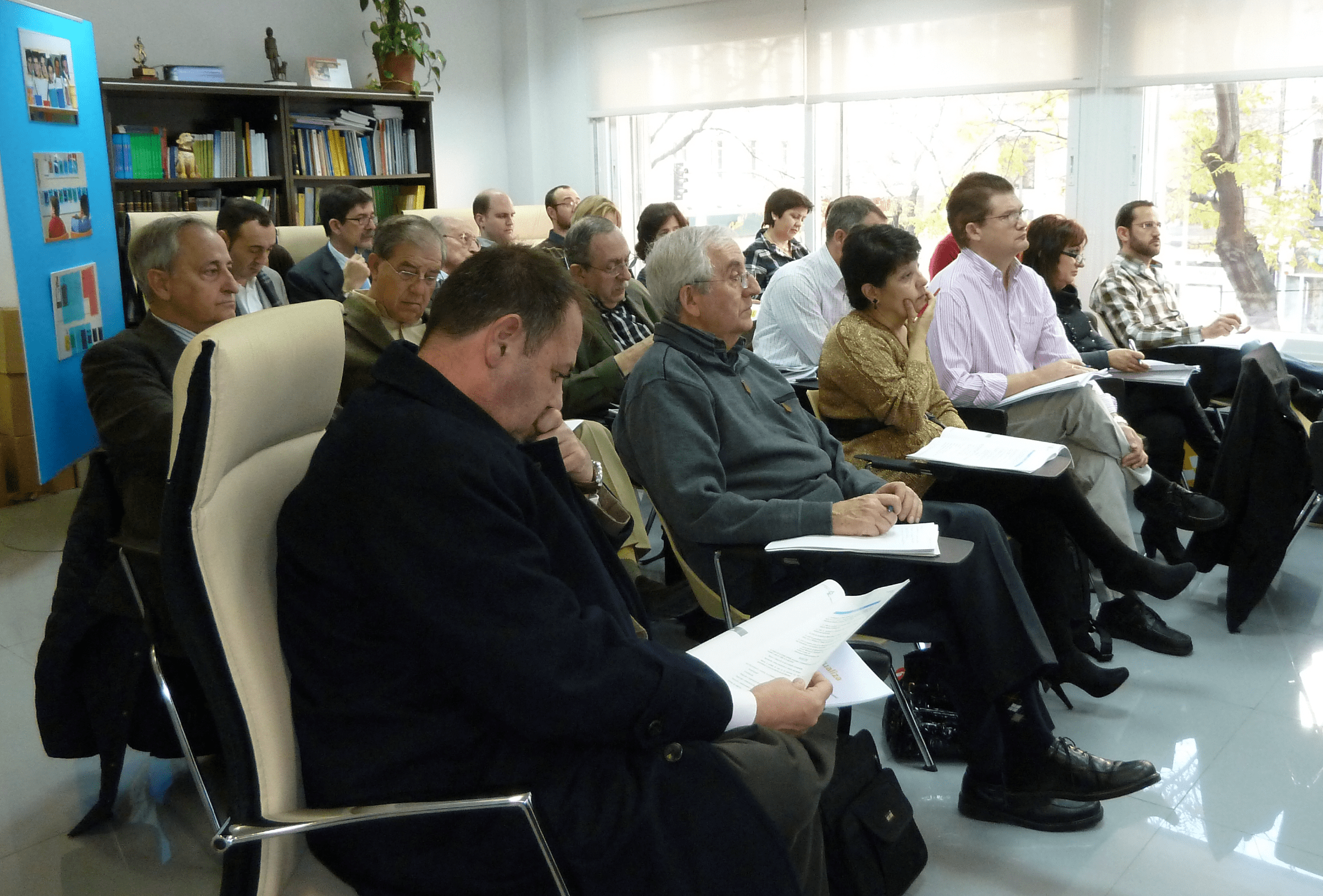 Un grupo de personas sentadas asistiendo a una conferencia