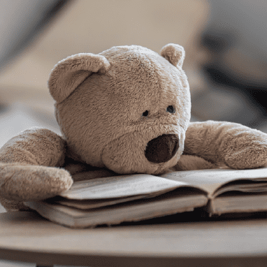 Imagen oso de peluche leyendo un libro