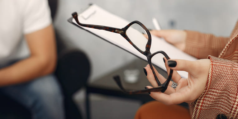 Miniatura de manos que sostienen un informe y unas gafas de ver