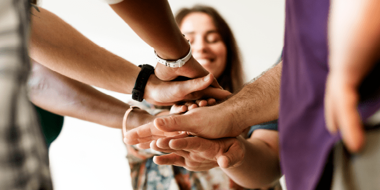 Miniatura de un grupo de personas juntando las manos