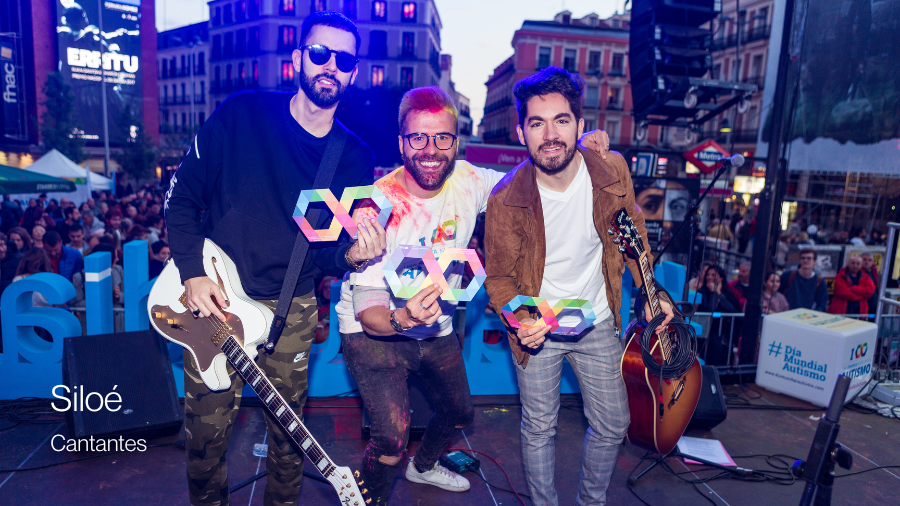 El grupo de música Siloé posando con un infinito multicolor