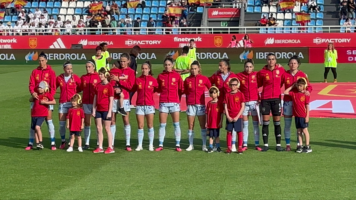 La selección femenina española de fútbol junto a un grupo de niños y niñas con autismo en el campo de juego