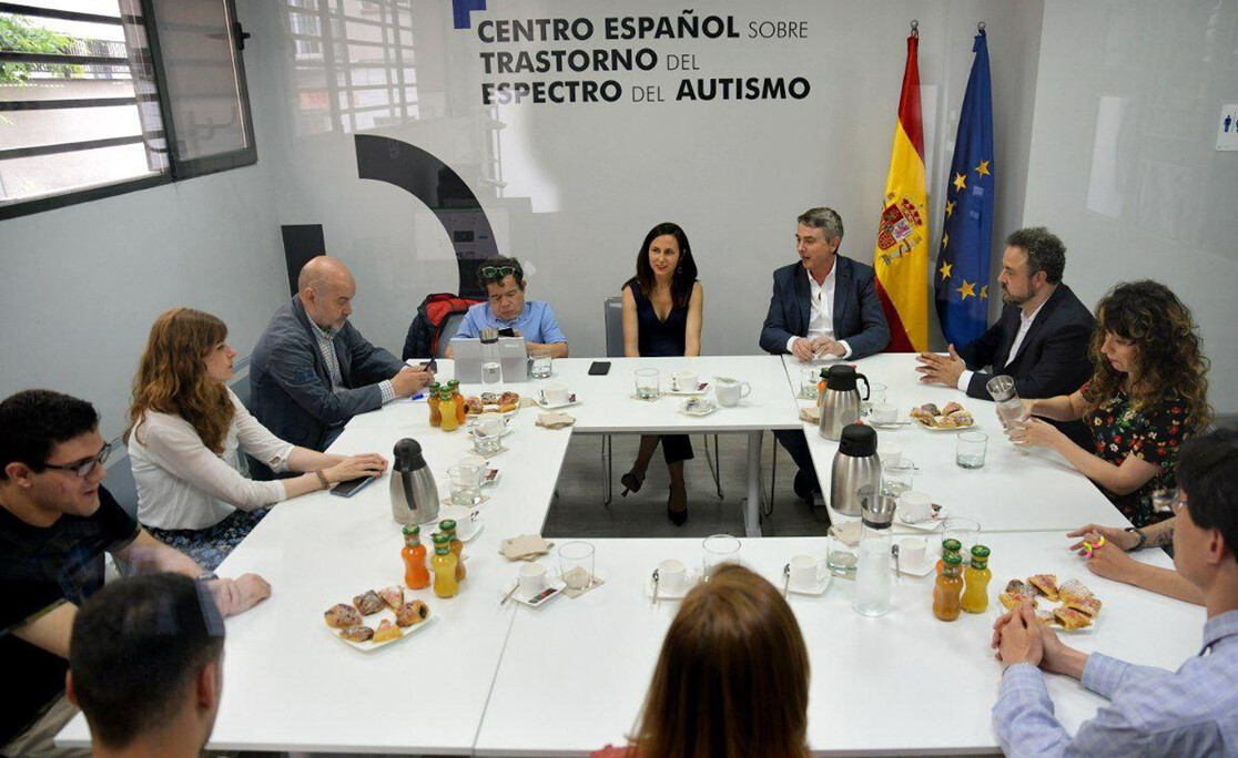 Varias personas reunidas con la Ministra de Derechos Sociales alrededor de una mesa en el Centro Español sobre trastorno del espectro del autismo