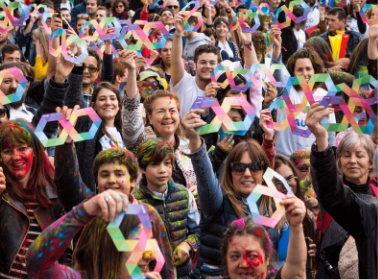 Una multitud celebrando el Día Mundial de Concienciación sobre el Autismo con infinitos de papel en sus manos