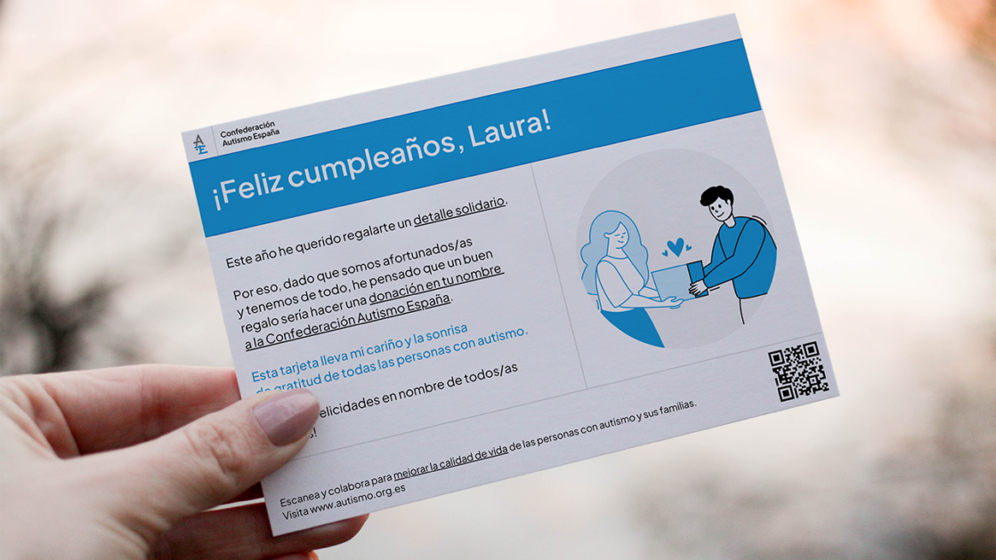 Una mano de mujer sujeta una tarjeta de cumpleaños solidaria de Autismo España