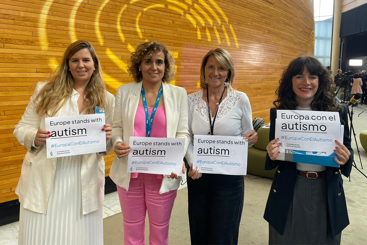 Fotografía de dos europarlamentarias junto a nuestras dos delegadas de asuntos públicos sujetando el cartel de Europa Con El Autismo