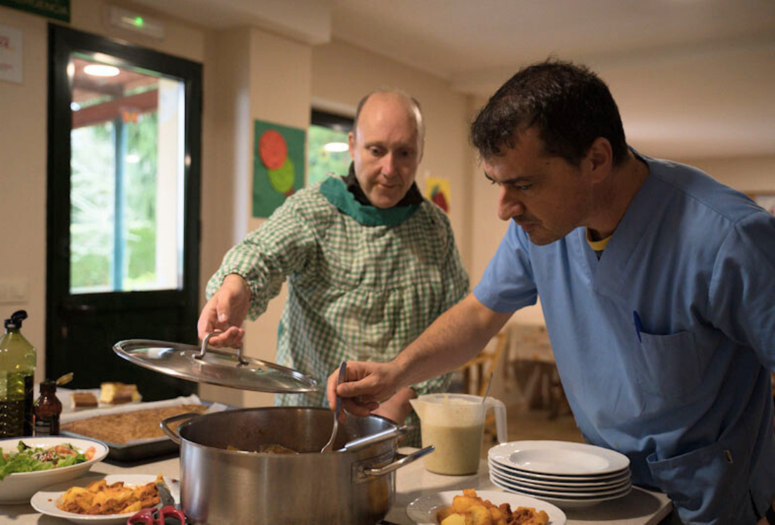 Dos hombres autistas haciendo comida en una olla