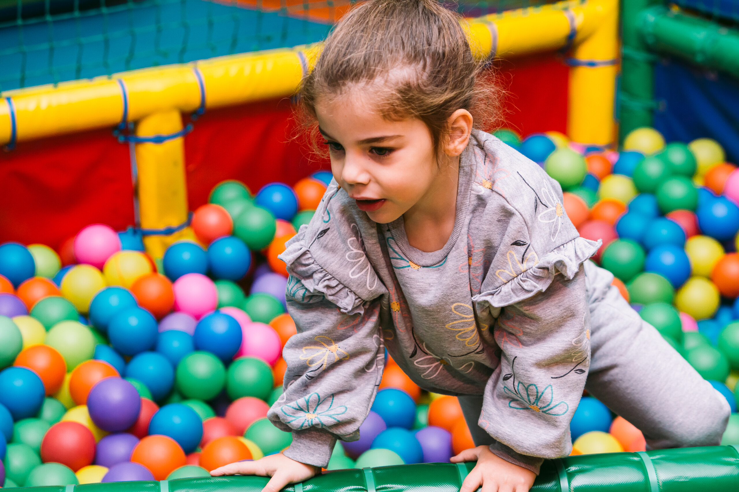 una niña jugando en un parque de bolas