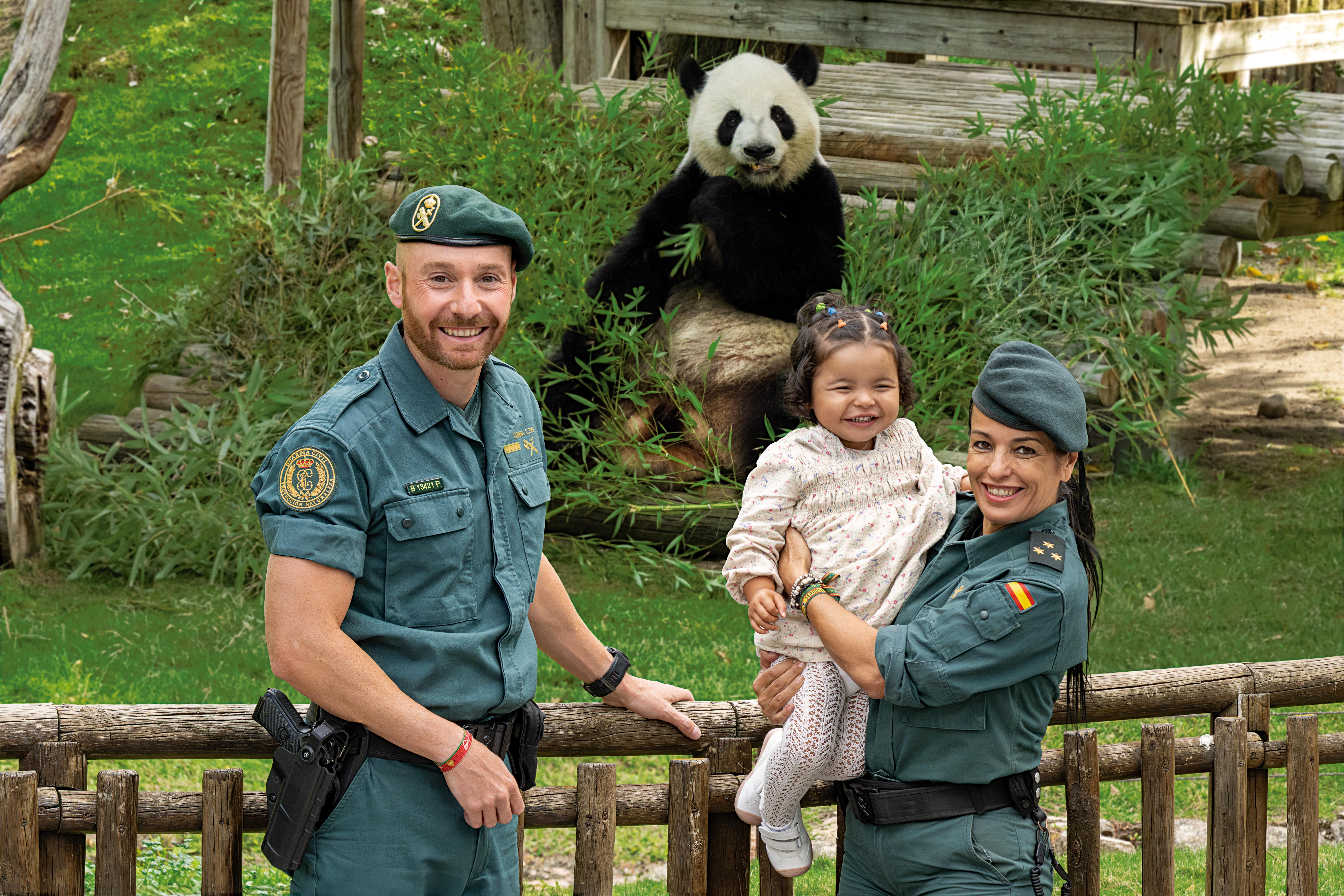 Foto niña autista y dos miembros del Seprona con un oso panda de fondo
