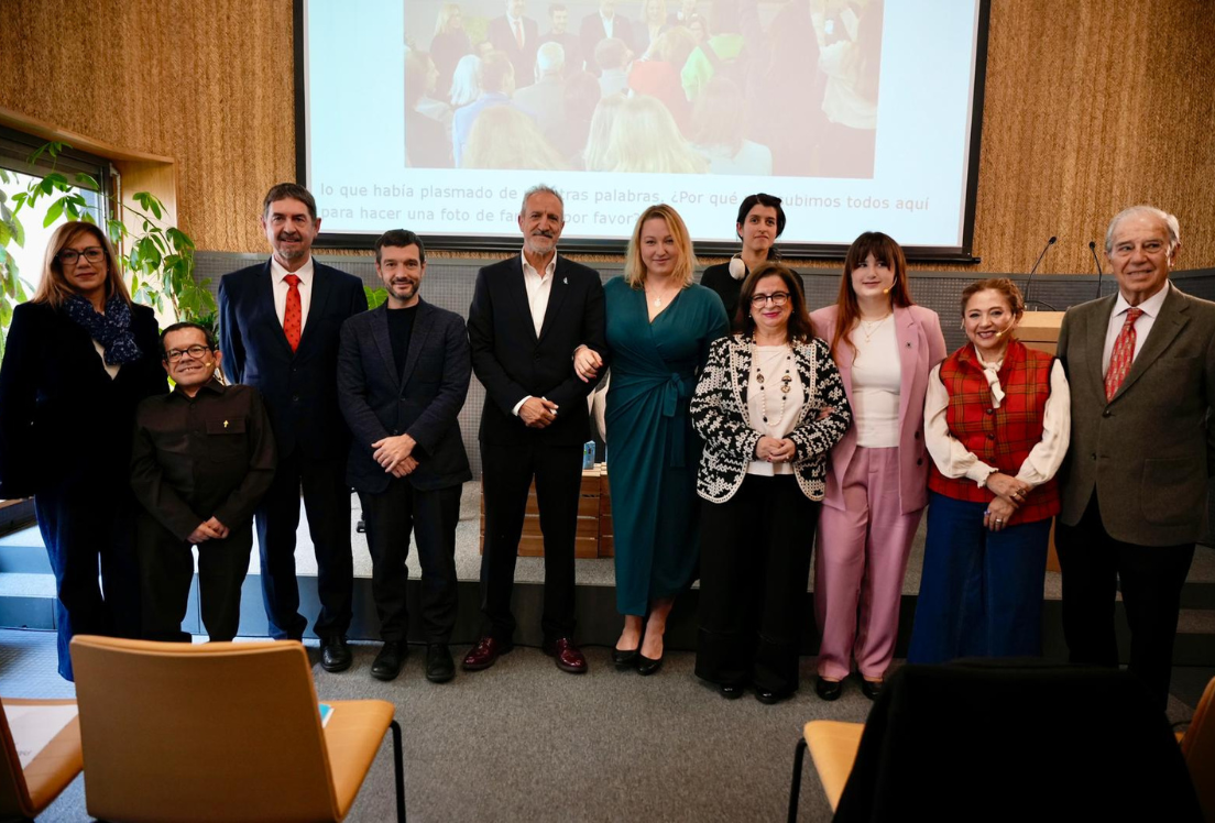 Un grupo de personas delante de un escenario con una pantalla detrás