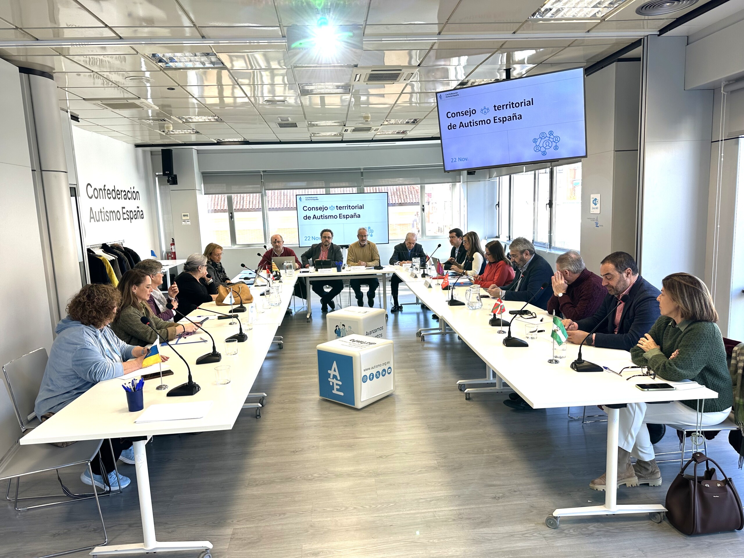 Una veintena de personas reunidas en una sala de reuniones