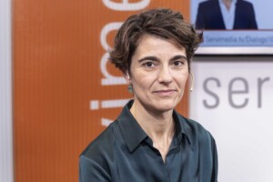 Primer plano de la secretaria de Estado de Derechos Sociales, sobre fondo naranja y blanco