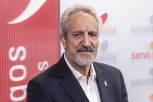 Primer plano del presidente de Autismo España delante de un fondo rojo y blanco