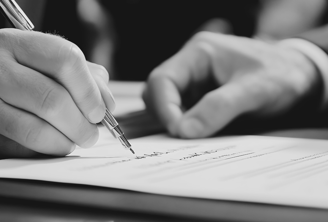 Dos manos firman un documento con un bolígrafo