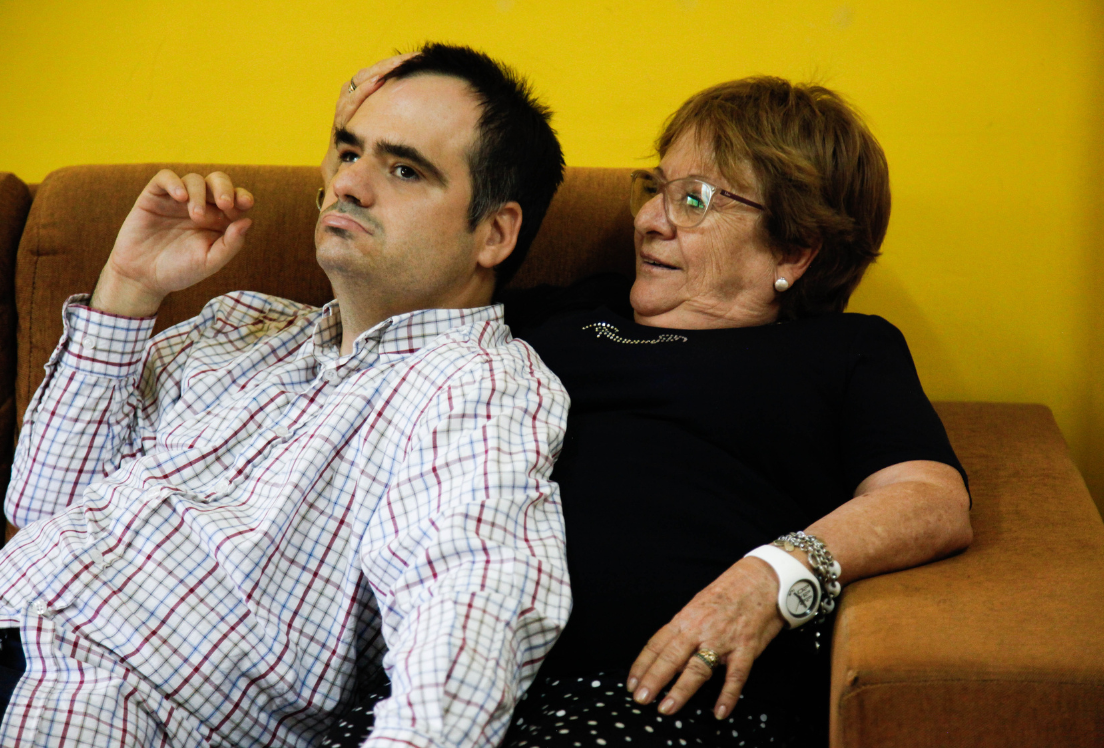 Imagen de un hombre recostado sobre una mujer en un sofá