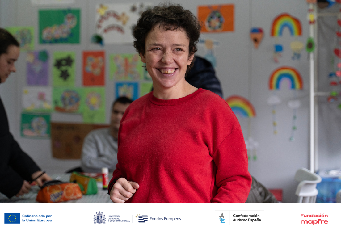 medio plano de mujer con jersey rojo y pelo corto riendo