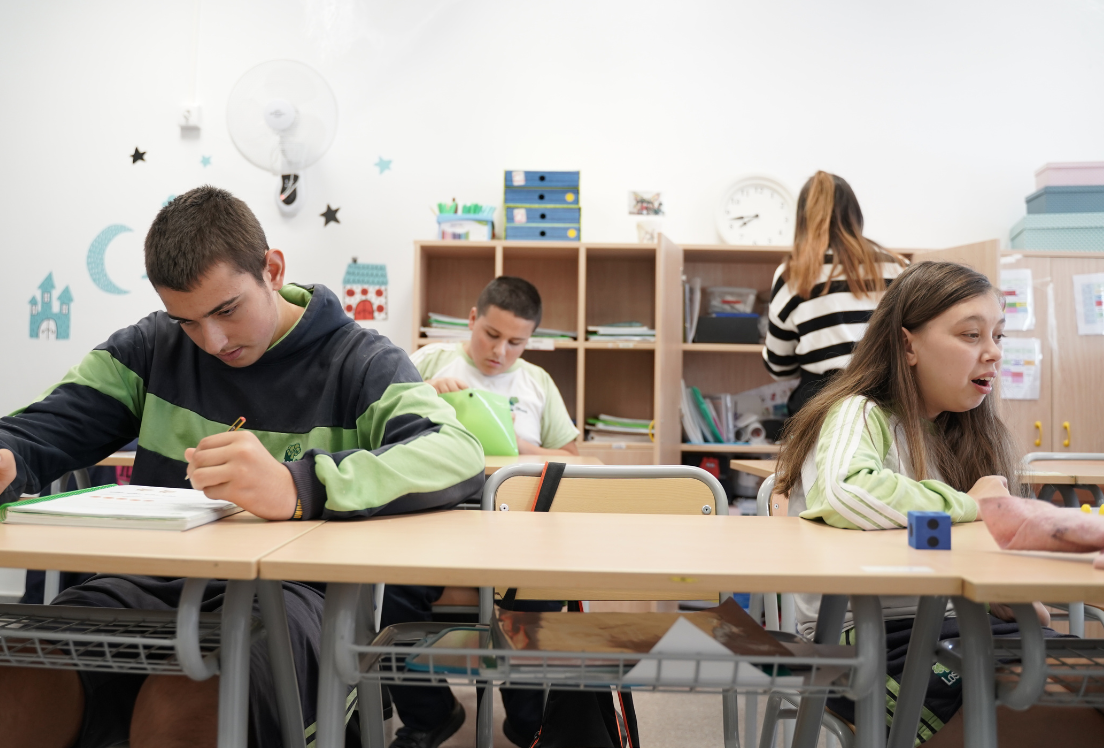 Unos adolescentes sentados en unos pupitres en un aula de un centro educativo