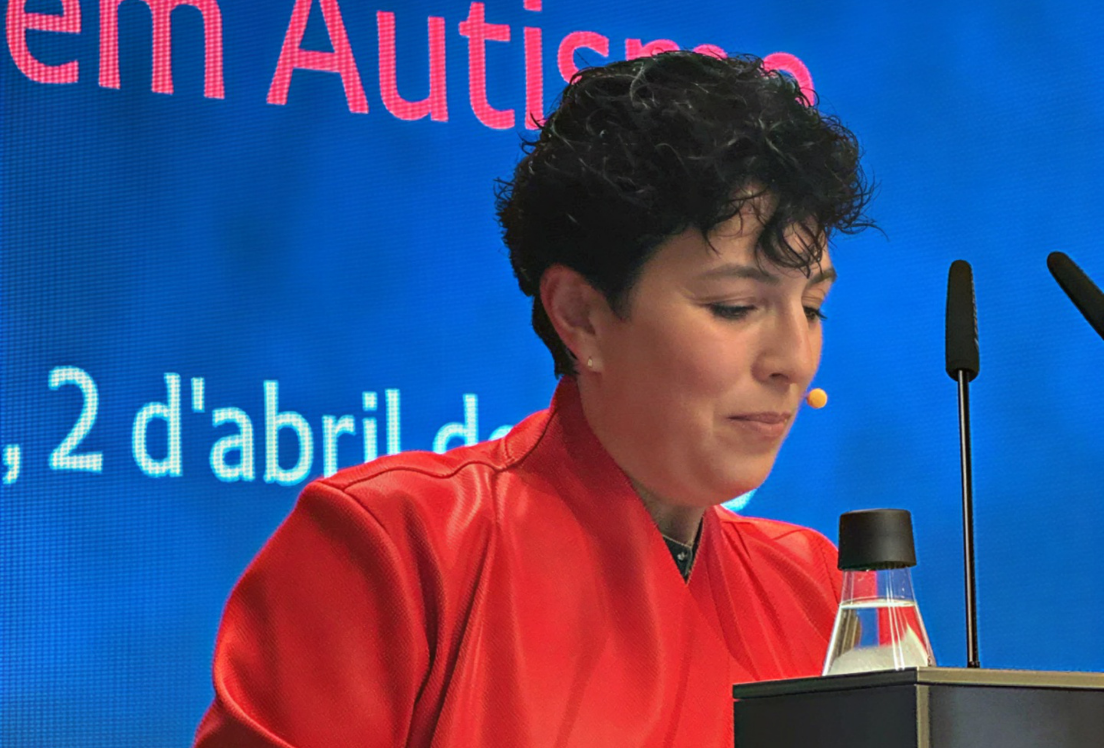 Primer plano de una mujer hablando desde un atril