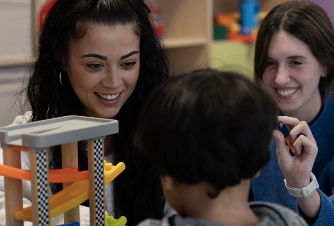 Dos mujeres jugando con un niño con autismo